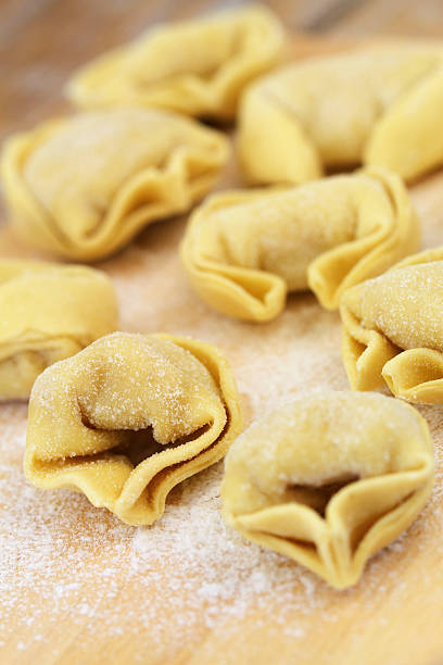 istock Uncooked tortellini on wooden board 489835496