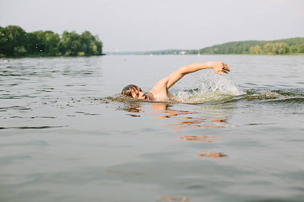 istock Young man swimming in a lake 489836084