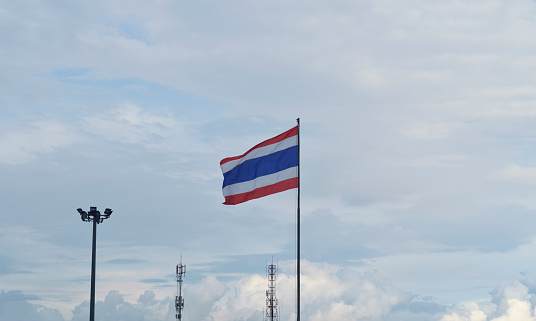 Thai flag waving against blue sky