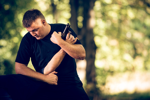 Martial arts instructors demonstrating self-defending from attacker with handgun.