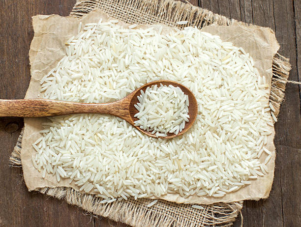 Basmati rice with a spoon Basmati rice with a spoon on an dark wood rice cereal plant stock pictures, royalty-free photos & images