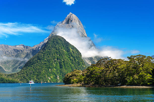 Milford Sound Famous Mitre Peak rising from the Milford Sound fiord and reflecting in water. Fiordland national park, New Zealand mitre peak stock pictures, royalty-free photos & images