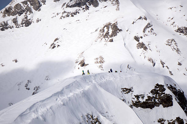 istock Snowboarders walking uphill for freeride 489869508