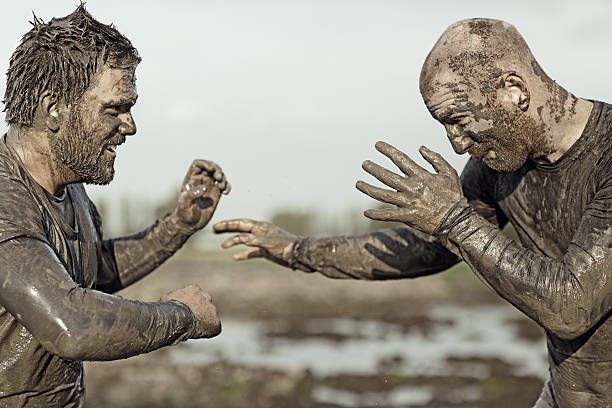 istock Two men sparring and wrestling in the mud 489869622