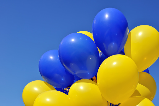 blue and yellow balloons in the city festival on blue sky background