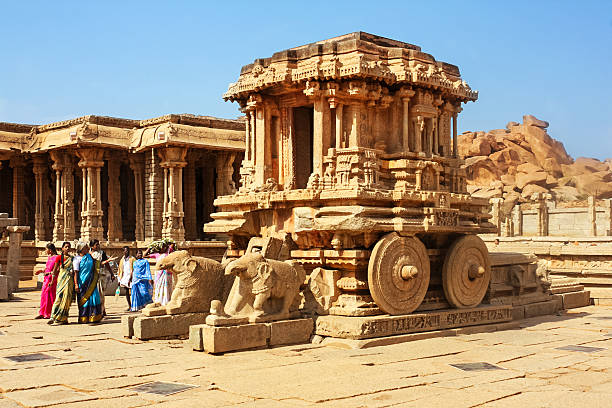Hampi, India - April 27, 2009: People visit the landmark stone chariot at the Vittala Temple complex in Hampi, India.