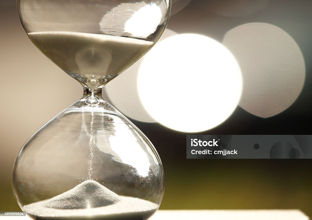 Modern Hourglass Modern Hourglass -- sand trickling through the bulbs of a crystal sand glass. every second counts. symbol of time. countdown.  Waiting Stock Photo