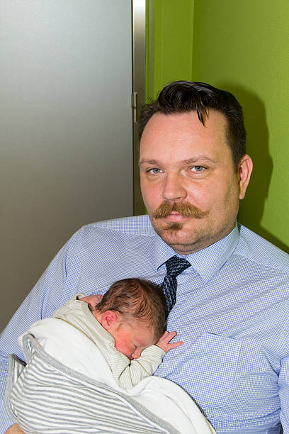 istock tired father with moustache and a newborn baby 489900068