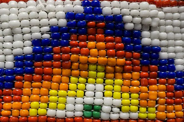 A macro photo of an Native American Indian headband with colorful beads and a triangular pattern.