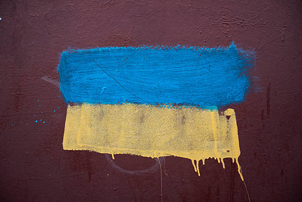 Ukrainian flag painted on metal wall The blue and yellow colors of the Ukrianian flag roughly painted on the metal wall of a pedestrian overpass in Mariupol, Ukraine. mariupol stock pictures, royalty-free photos & images
