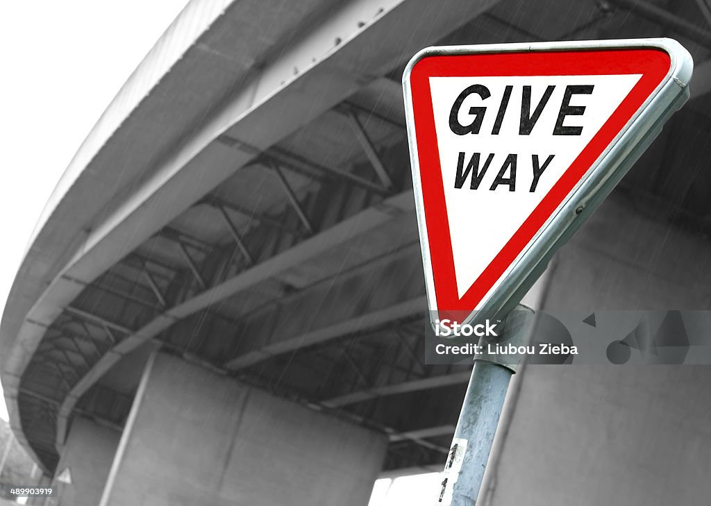 Road sign Give Way Road sign Give Way. British road sign Give Way opposite the motorway bridge by rainy day Black And White Stock Photo