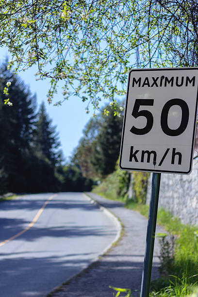 istock Speed limit sign beside a quiet road. 489904148