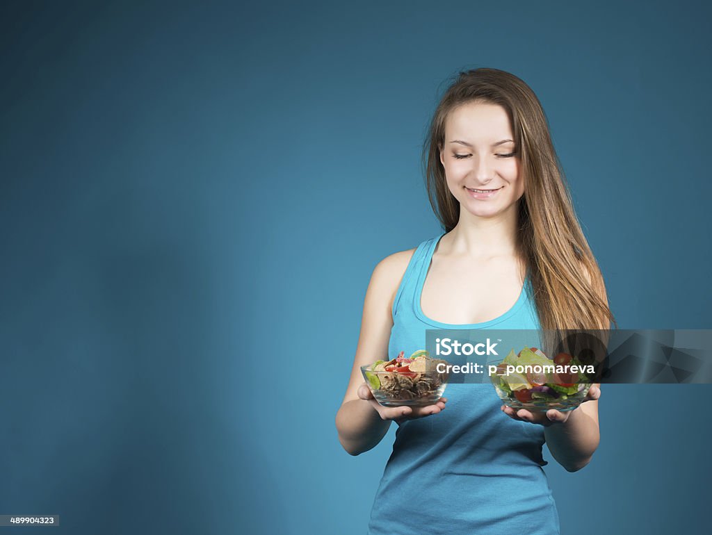 Young Woman With Fresh Salad And Cereal On Blue Background. Diet. Dieting concept. Healthy Food. 20-29 Years Stock Photo