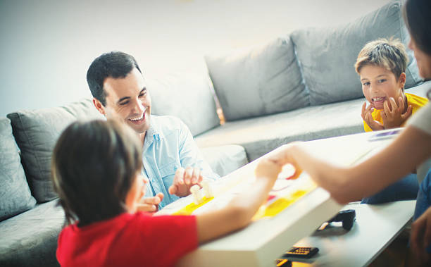 istock Young family playing board game at home. 489905026
