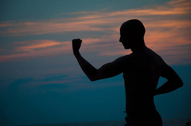 istock Sunset silhouette of a man practicing martial arts 489906534