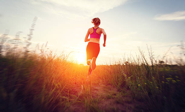 istock Young woman running on a rural road at sunset 489906738