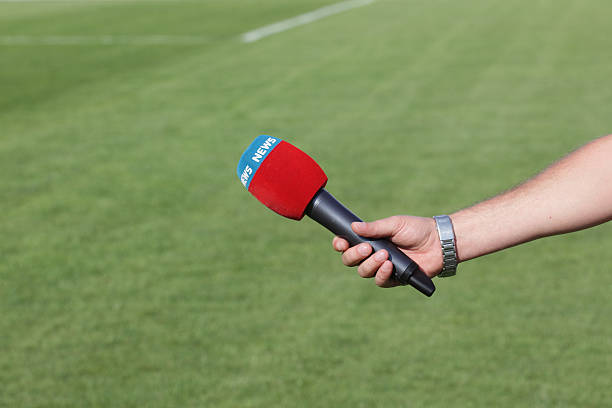 istock hand holding microphone for interview during a football mach 489907139
