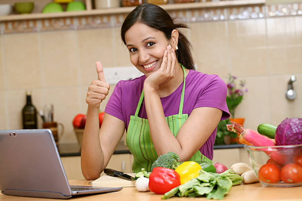 junge frau machen daumen hoch geste - stereotypical housewife women domestic kitchen brown hair stock-fotos und bilder