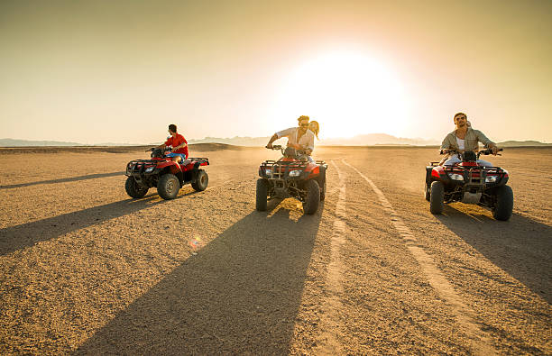 istock Friends driving quad bikes in the desert at sunset. 489907820