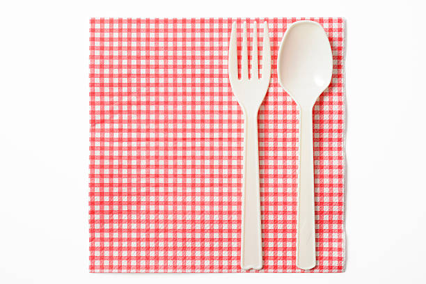 istock Pink paper napkin with knife and fork on white background 489909867