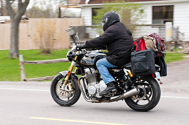 Black Norton Commando 961SE - Side View Fonthill, Ontario, Canada - May 04, 2014: A guy riding by on a 2013 Norton Commando 961 SE motorcycle with loaded saddle bags in Fonthill, Ontario Canada norton brand name stock pictures, royalty-free photos & images