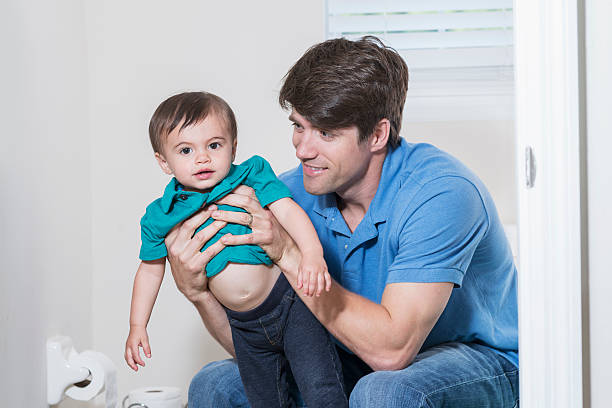 istock Father in bathroom, holding 1 year old son 489910360