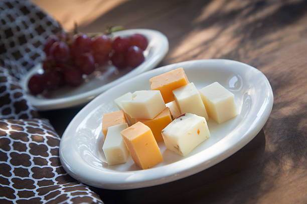 сырная тарелка с красный виноград сидлис - cheese tray cube swiss cheese стоковые фото и изображения