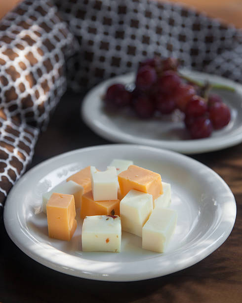 сырная тарелка с красный виноград сидлис - cheese tray cube swiss cheese стоковые фото и изображения