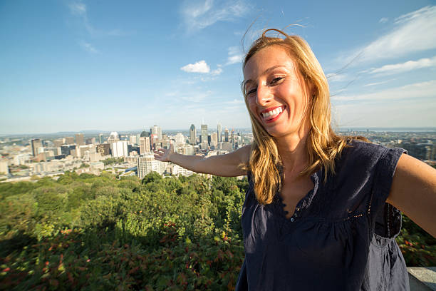 istock Young cheerful woman in Montreal-Canada taking selfie using mobile phone 489925268