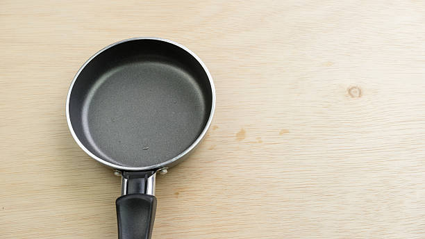 istock Empty black color metal mini frying pan on wooden surface 489925500