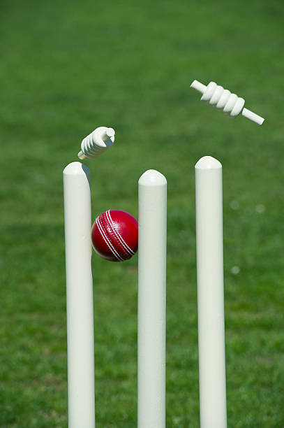 Cricket ball and stumps Cricket ball stumps the wicket as bails fly on the field cricket stump photos stock pictures, royalty-free photos & images