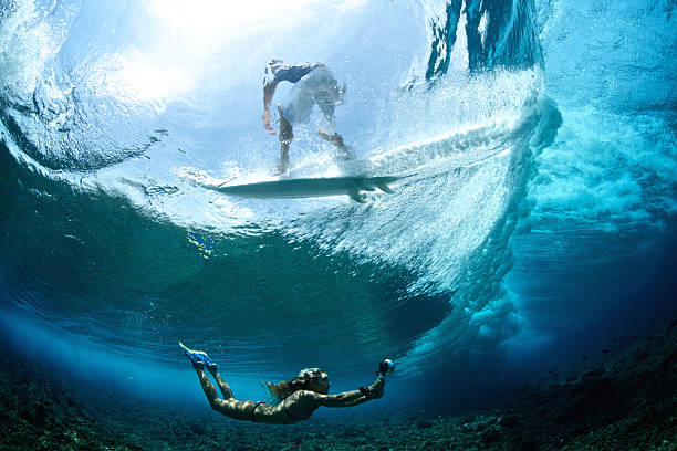 istock Girl swims under a wave that surfer rides 489930108