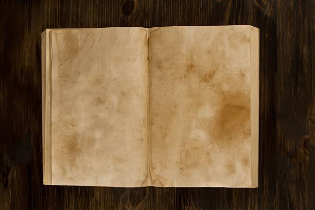 istock open old vintage book on the aged wooden background. 489930656