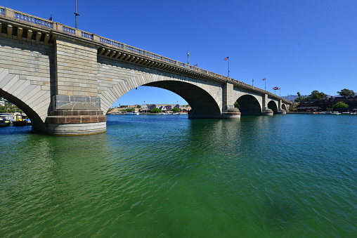 London Bridge is a bridge in Lake Havasu City, Arizona, United States. It is a relocated 1831 bridge that formerly spanned the River Thames in London, England, until it was dismantled in 1967. The Arizona bridge is a reinforced concrete structure clad in the original masonry of the 1830s bridge, which was bought by Robert P. McCulloch from the City of London. McCulloch had exterior granite blocks from the original bridge numbered and transported to America to construct the present bridge in Lake Havasu City, a planned community he established in 1964 on the shore of Lake Havasu. The bridge was completed in 1971 (along with a canal), and links an island in the Colorado River with the main part of Lake Havasu City.