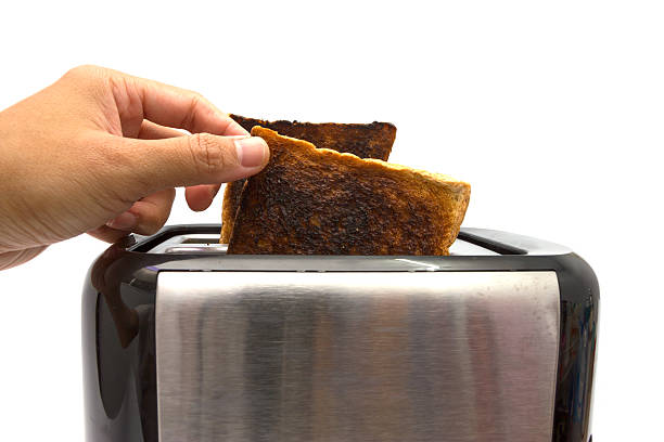 istock Hand taking burnt toast out of toaster 489931814
