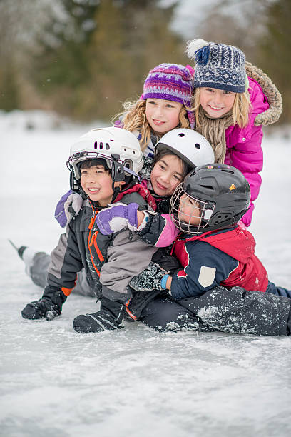 grupo de crianças em um lago gelado - ice skating ice hockey child family imagens e fotografias de stock