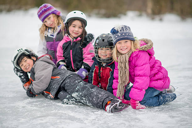 mientras los niños juegan en la pista de patinaje sobre hielo - ice skating ice hockey child family fotografías e imágenes de stock