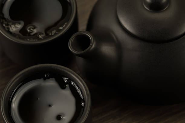 istock Black teapot, two cups on old wooden background. Close up 489932210