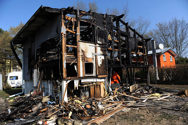 istock House destroyed by fire with policemen 489933358