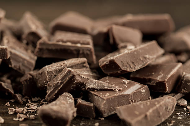 istock Broken chocolate bar on wooden background, close-up 489933448