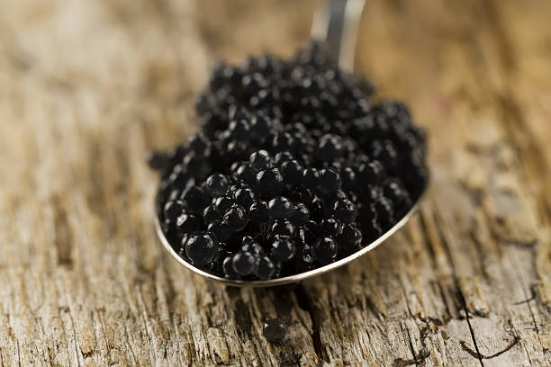 istock black Beluga caviar in spoon on wooden background 489934236