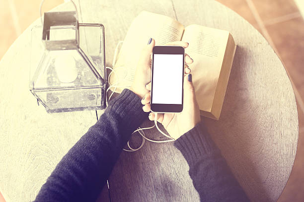 istock Girl with blank cell phone, headphones and a book 489934498
