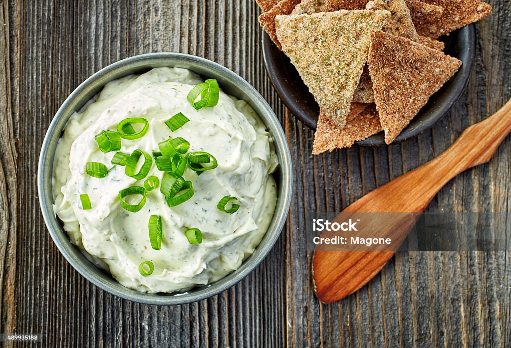 cream cheese with green onions and herbs bowl of cream cheese with green onions and herbs, dip sauce on wooden table, top view Dipping Sauce Stock Photo