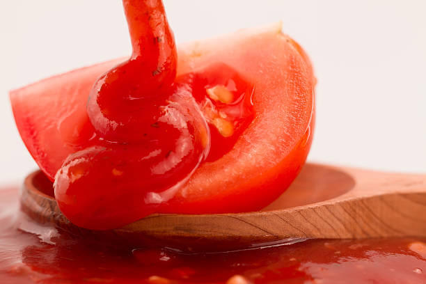 istock Tomato ketchup in a wooden spoon on a white background. 489935826