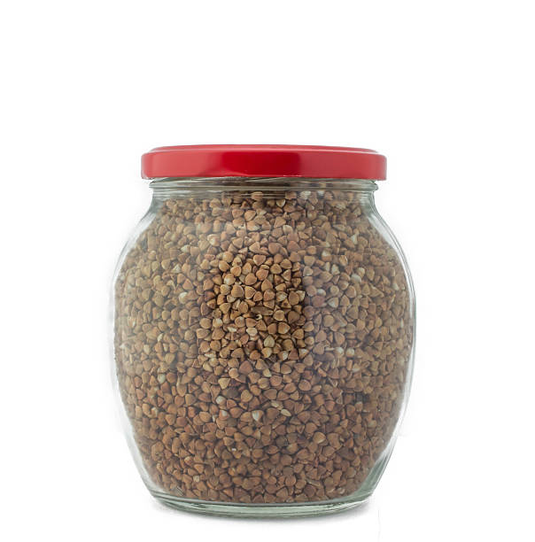 istock Glass jar with buckwheat closed red cap isolated 489948314