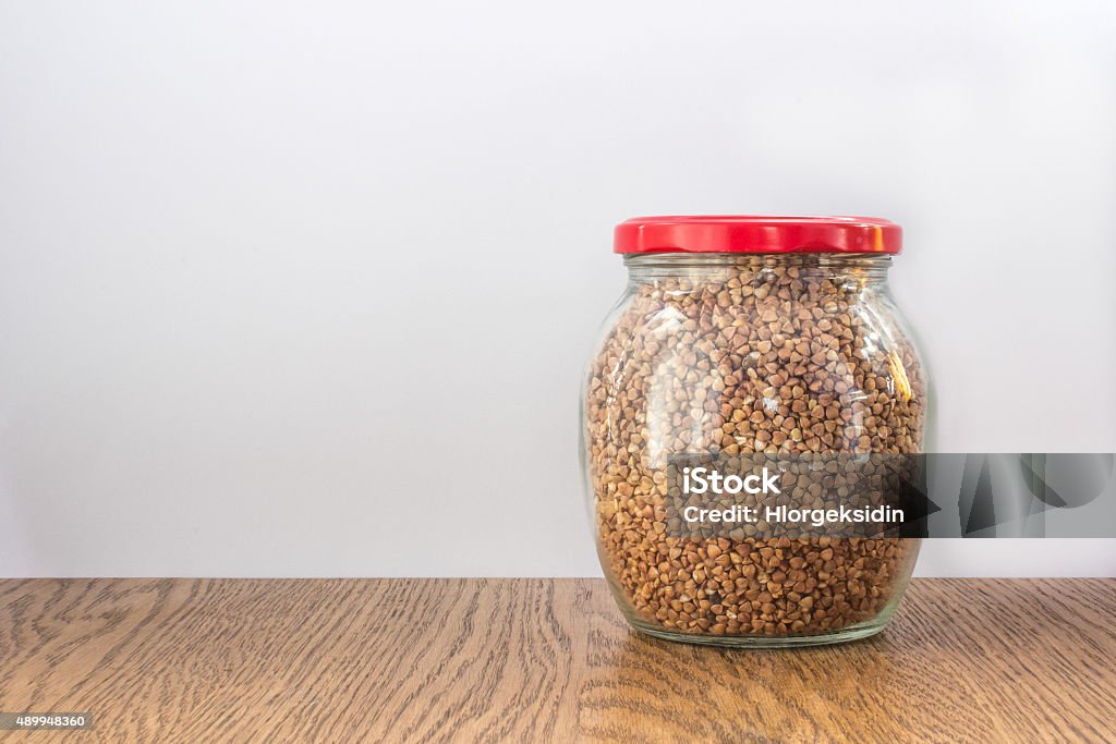 Pote cheio de trigo sarraceno fechado com vidro vermelho cap de madeira - Foto de stock de 2015 royalty-free