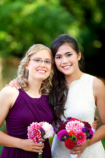 istock Beautiful biracial young bride smiling with her bridesmaid 489950112