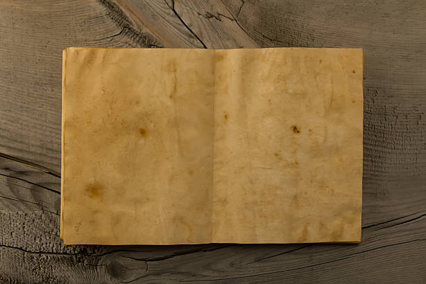 istock open old vintage book on the aged wooden background. 489950842