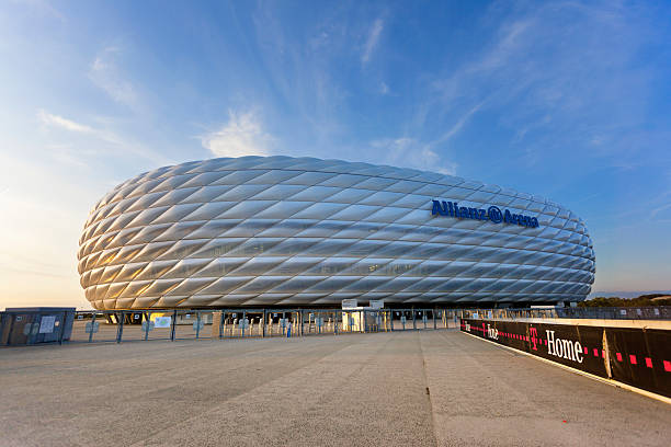 Dawn over illuminated soccer stadium Allianz Arena in Munich Munich, Germany - August, 14th 2009: Night shot of the Soccer stadium Allianz Arena in Munich with the membrane shell illuminated with white which means that there will be county matches or a match of the Champions League  allianz arena stock pictures, royalty-free photos & images