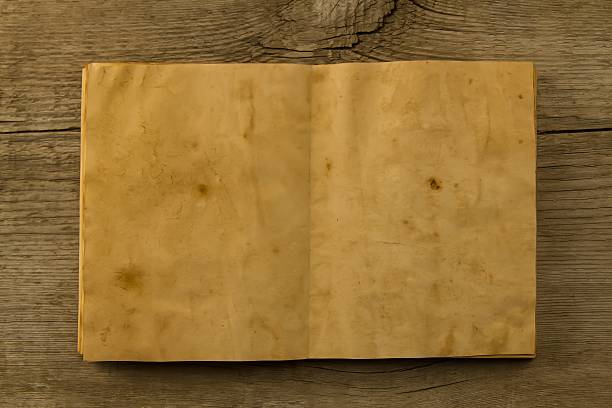 istock open old vintage book on the aged wooden background. 489951124